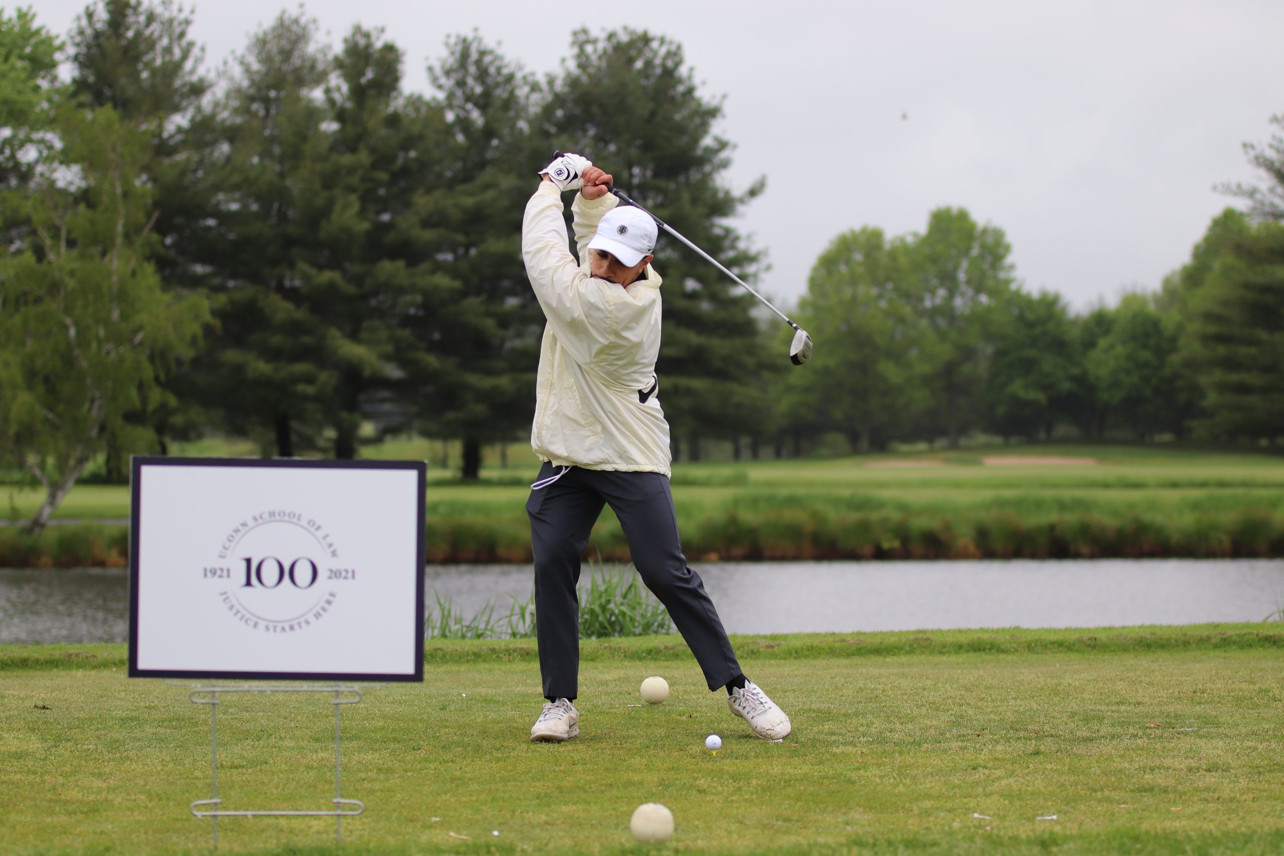 Attendee hits off the tee at the Centennial Golf Tournament